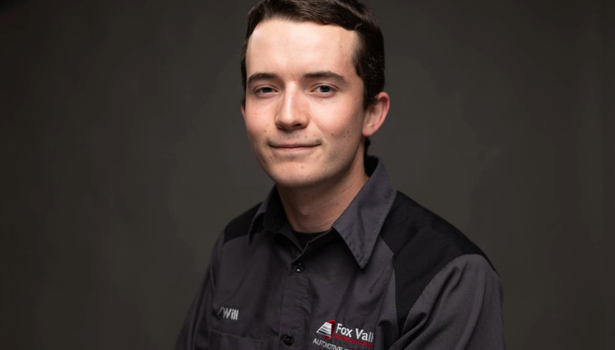 A person with short dark hair, wearing a gray and black uniform with a logo that reads Fox Valley Tech