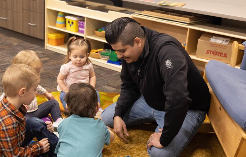 FVTC student kneeling by a group of children in FVTC's child care center
