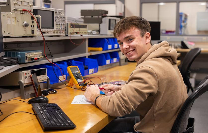 FVTC engineering student sitting at table working on a device