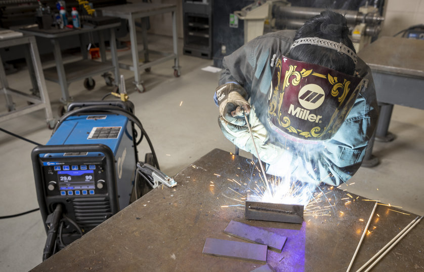 FVTC student wearing welding mask welding piece of metal