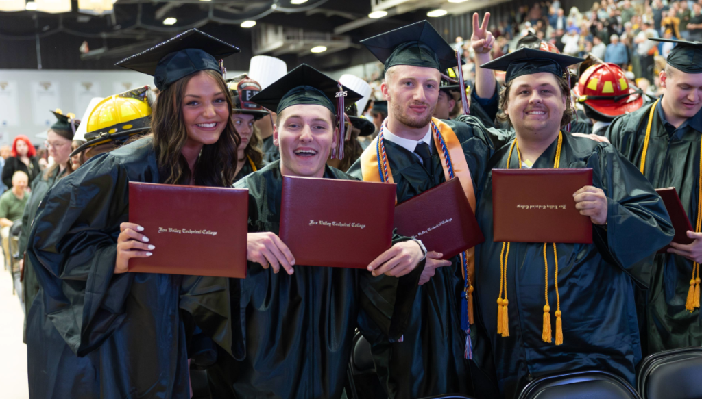 a group of people in graduation gowns and caps holding diplomas