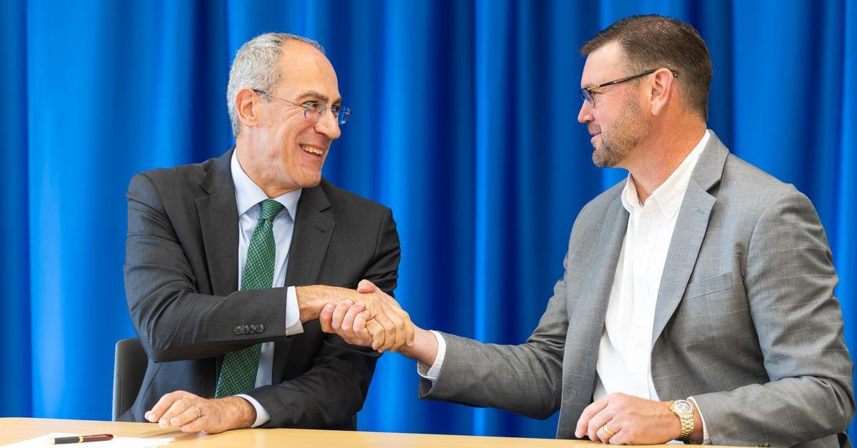 A college president and chancellor shaking hands.