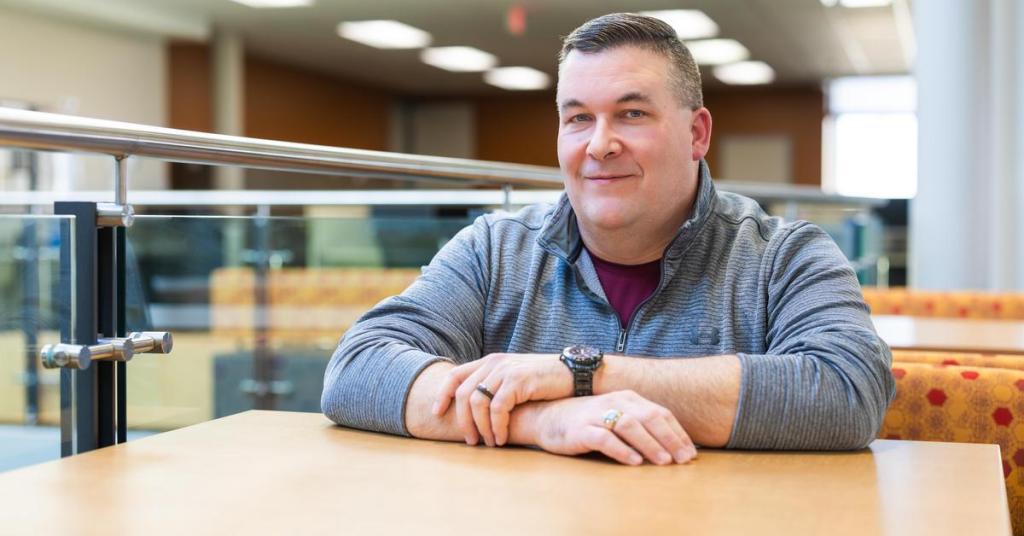 student speaker sitting at table and smiling