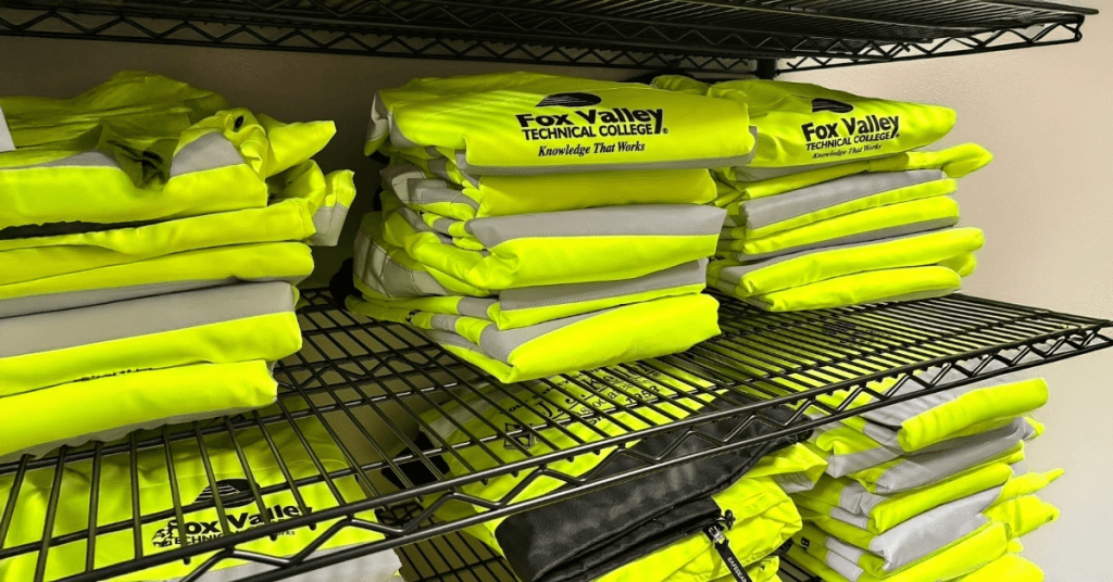 Yellow safety jackets stacked on shelf