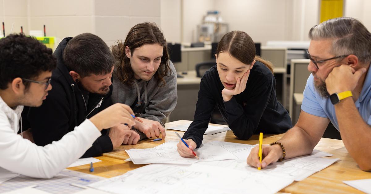 Faculty member working on drafting with students.