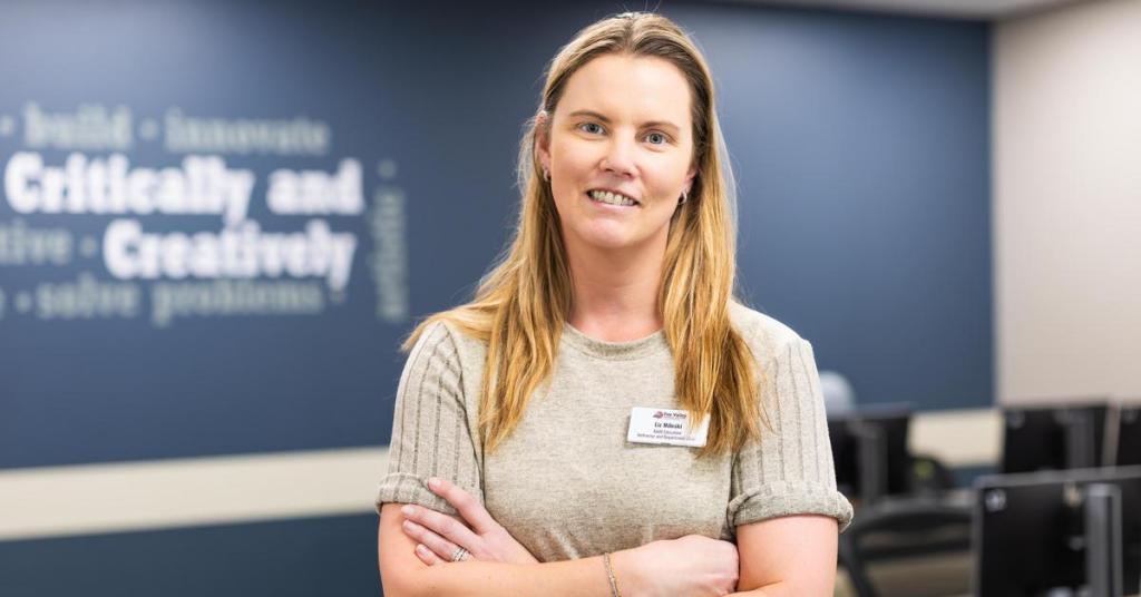 Faculty member Liz Mileski smiling in a classroom.