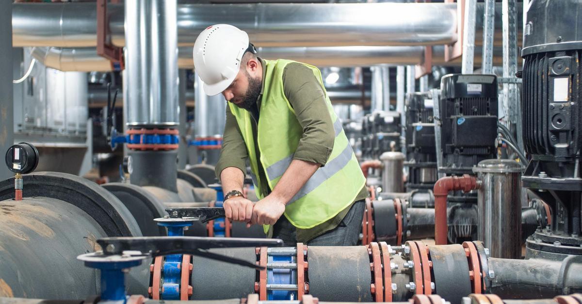 Male engineer working on valve in a factory.