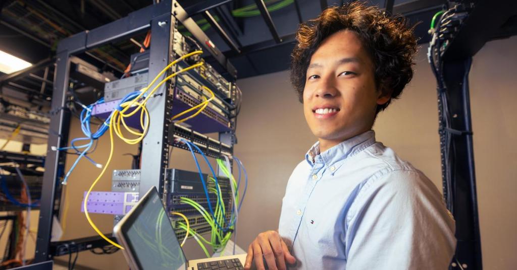 Networking student Joshua in a campus networking lab.